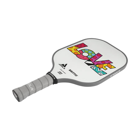 White Background Image: JOOLA x BRITTO paddle, grey handle, white paddle face with LOVE written in colorful BRITTO art style.