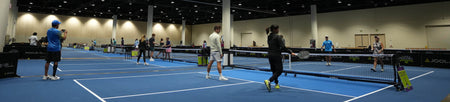 Horizontal banner image showing a mix of players at an indoors space playing pickleball.