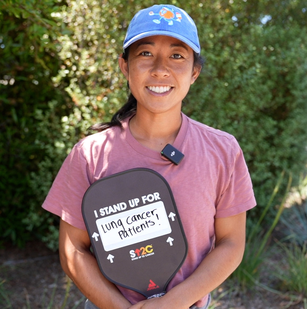 Bobbi posing with customized Stand Up 2 Cancer pickleball paddle.