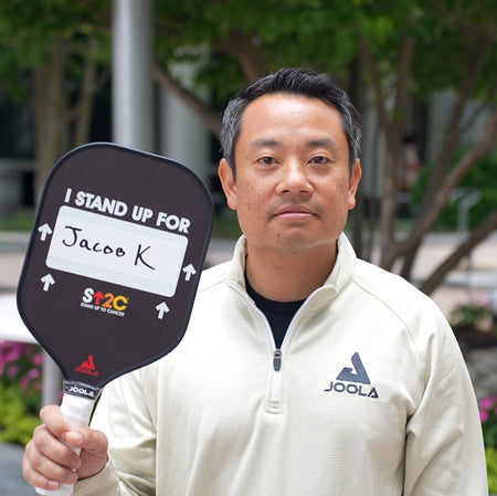 Tom posing with customized Stand Up 2 Cancer pickleball paddle.