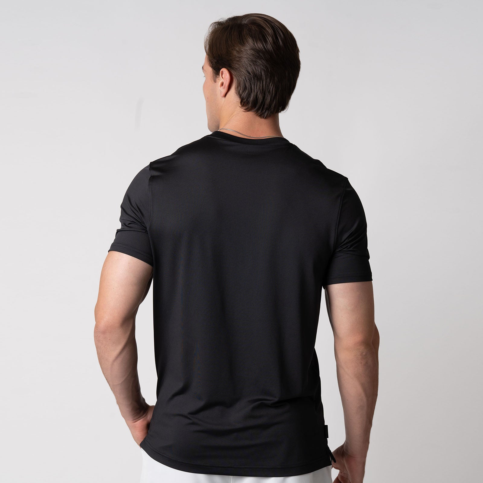 Image showing the back of a male model wearing a JOOLA Men's Club Short Sleeve Shirt, Black.